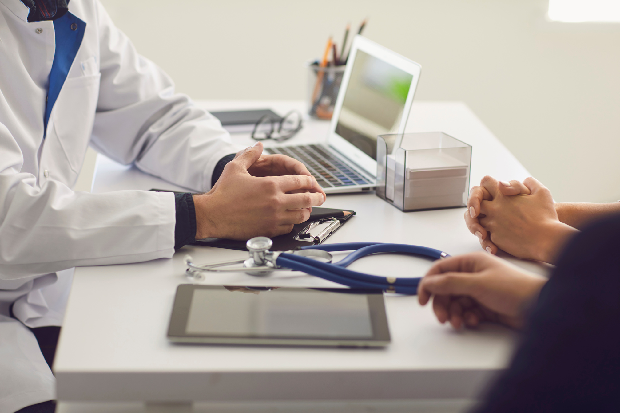 a doctor is talking to two people at a desk