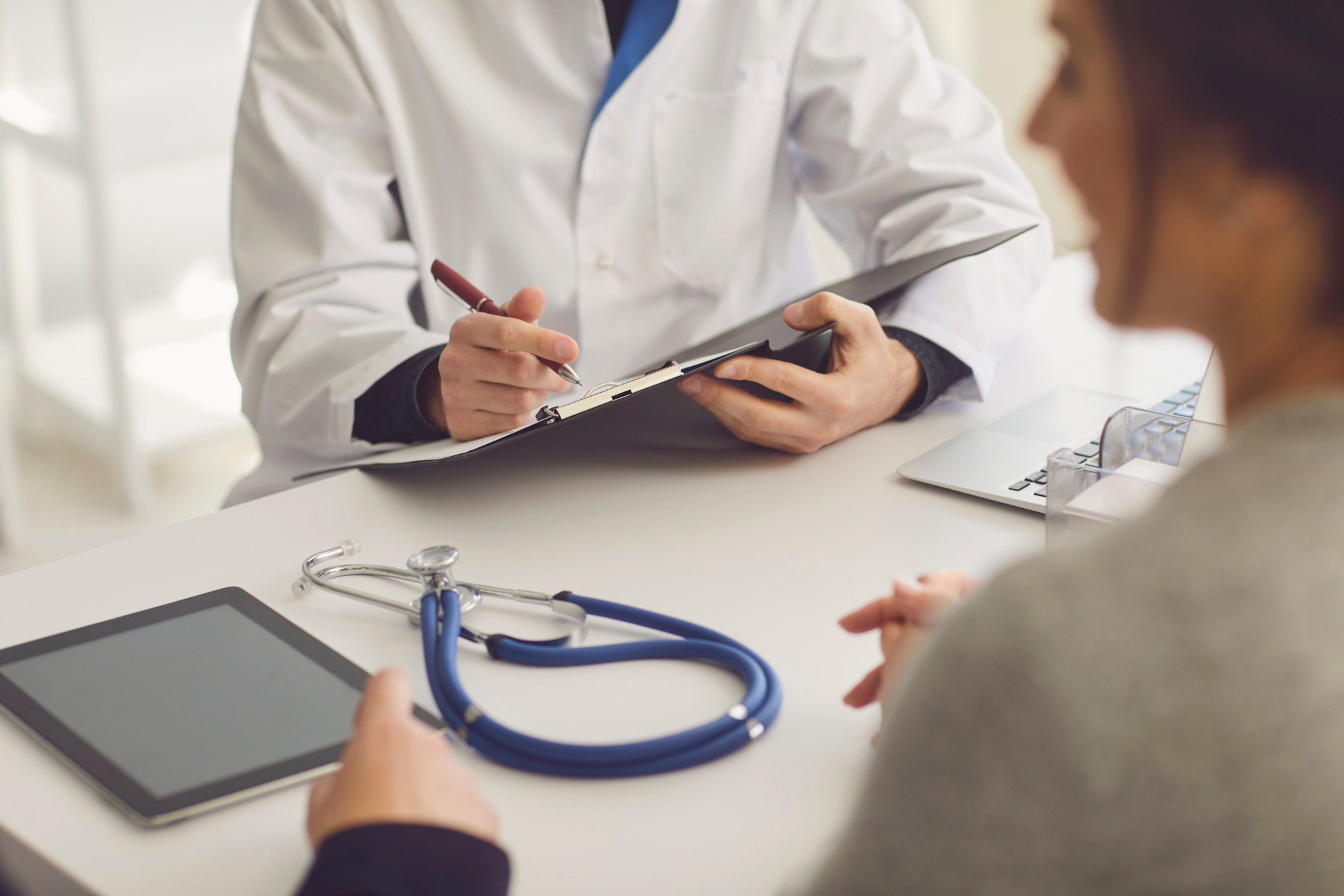 a doctor is talking to a patient at a desk